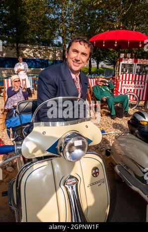 Quadrophenia-Star Phil Daniels eröffnete das Goodwood Revival, indem er eine Gruppe von „Mods“ auf der Rennstrecke leitete. Sitzen auf einem Lambretta Motorroller. Stockfoto