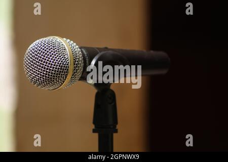 Nahaufnahme des dynamischen Gesangsmikrofons, das auf dem Ständer angebracht ist, mit Platz für Textsprache und Gesangskonzept Stockfoto