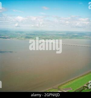 Eine Luftaufnahme des zweiten Severn Crossings aus dem Südosten. Die zweite Severn Crossing dauerte vier Jahre und war ein gemeinsames Tiefbauprojekt zwischen Laing Civil Engineering und dem französischen Unternehmen GTM. Die Arbeiten begannen im April 1992 und die Eröffnungszeremonie fand später am 5. Juni 1996 statt. Die Überfahrt ist eine Kabelbrücke, die sich über 5000 Meter über den Fluss Severn erstreckt, der England und Wales verbindet, 3 Meilen stromabwärts von der Severn Bridge, die 1966 eröffnet wurde. Stockfoto