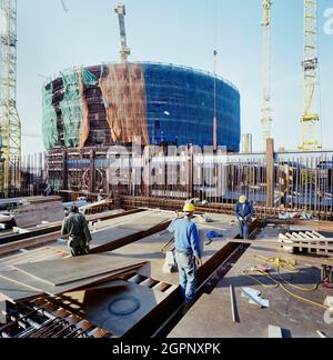 Männer, die am Bau des Hilfsgebäudes des Reaktors im Kernkraftwerk Sizewell 'B' arbeiten. Sizewell 'B' ist eines von zwei Kernkraftwerken an der Küste von Suffolk in der Nähe des Dorfes Sizewell. Sizewell 'A', sein Vorgänger, ist dabei, stillgelegt zu werden. Sizewell 'B' ist ein Druckwasserreaktor (PWR), der erste seiner Art in Großbritannien. John Laing plc wurde am 19. Mai 1987 der Auftrag für die wichtigsten Tiefbauarbeiten erteilt. Sizewell 'B' wurde 1995 nach 8 Jahren Bauzeit fertiggestellt und wird von EDF Energy betrieben. Stockfoto