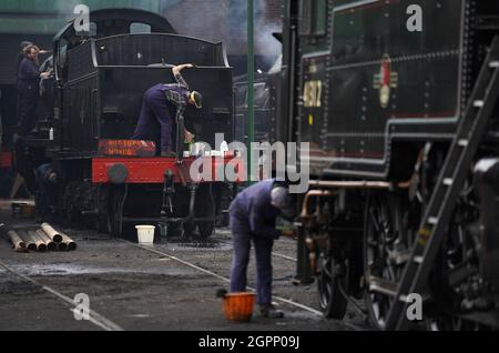 Freiwillige arbeiten an Dampflokomotiven auf dem Ropley-Hof der Mid Hants Railway, auch bekannt als Watercress-Linie, einer Dampfeisenbahnstrecke aus dem 19. Jahrhundert in Hampshire, im Vorfeld der Herbstdampfgala, die vom 1. Bis 3. Oktober stattfindet. Die diesjährige Autumn Steam Gala, die in Zusammenarbeit mit dem Somerset und Dorset Railway Trust die Somerset- und Dorset-Eisenbahn aus den 50er und 60er Jahren nachbaut. Bilddatum: Donnerstag, 30. September 2021. Stockfoto