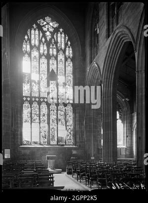 St. John the Baptist's Church, Fleet Street, Bablake, Coventry, 1941. Ein Blick entlang des Kirchenschiffs auf das Taufbecken in der Kirche des heiligen Johannes des Täufers, der Schäden am Westfenster zeigt. Während des Coventry Blitz St. John's erlitt Bablake Bombenschäden an den Fenstern und dem Dach. Stockfoto