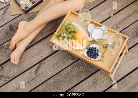 Tolle Zeit, um sich auf dem hölzernen Pier mit Tisch mit Wein und Obst zu entspannen. . Erholung und Reisen. Schöne Sommerabende.Tourismus und Unterhaltung. S Stockfoto