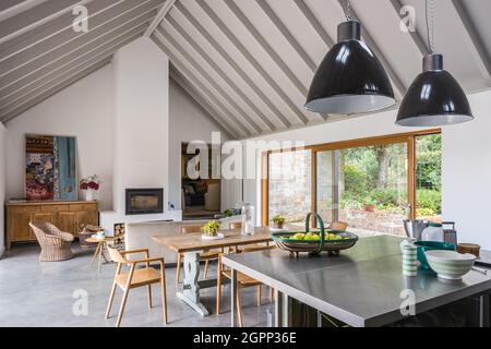 Zwei Pendelleuchten über der Kücheninsel im neu erbauten Sussex-Bauernhaus, Großbritannien Stockfoto