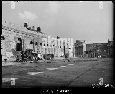 Market Hall, Worcester Street, Bull Ring, Birmingham, 1941. Bauarbeiter neben einem Triebwerk in der Bombe bombardierten die Markthalle. Die ehemalige Markthalle stammt aus den 1830er Jahren. Sie wurde während des Birmingham Blitz zerstört und blieb als leere Hülle erhalten, bis sie 1963 im Rahmen der Entwicklung des Bull Ring Centers abgerissen wurde. Diese Ansicht zeigt die zugemauerten Fenster und das fehlende Dach als Folge der am 25. August 1940 heruntergekommenen Brandvorrichtungen. Stockfoto