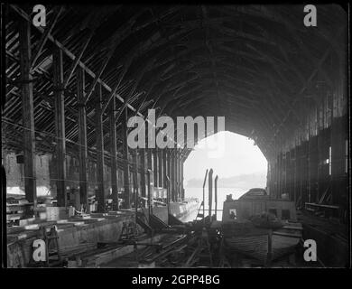 Devonport Dockyard, South Yard, Covered Slip No. 1, Devonport, Plymouth, 1942. Das Innere von No. 1 deckte den Schlupf im South Yard von Devonport Dockyard ab. Die Nummer 1 der Slipanlage am South Yard stammt aus den 1770er Jahren. Der Fachwerkdeckel, entworfen von Sir Robert Seppings, wurde 1814 errichtet. Zum Schutz von Holzschiffen wurden während des Baus Abdeckungen für Slips eingeführt, die zu dieser Zeit zu den breitesten Dächern Großbritanniens gehörten und die späteren Eisenschuppen der Eisenbahnzeit vorweglösten. Stockfoto