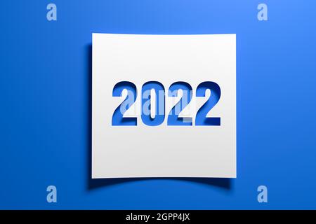 Ein Stück gebogenes Memopapier mit der ausgeschnittenen Zahl 2022 auf blauem Hintergrund. Konzept für Veranstaltungen im Jahr 2022 und Neujahr 2022. Stockfoto