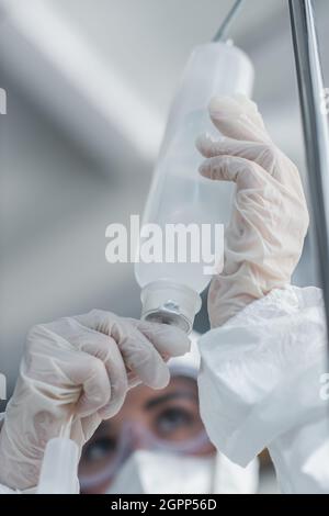 Beschnittene Ansicht des Arztes in Latexhandschuhen, die den Katheter auf dem Fallzähler halten Stockfoto