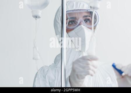 Arzt mit persönlicher Schutzausrüstung und Schutzbrille, der auf den Fallzähler schaut Stockfoto