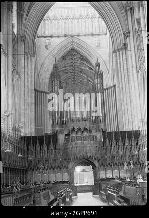 York Minster, Minster Yard, York, 1942. Eine Innenansicht des York Minster, auch bekannt als St. Peter's Cathedral Church, mit Blick nach Westen vom Chor und der Chorleinwand und der Kreuzung im Hintergrund. Die Chorleinwand befindet sich unter dem östlichen Kreuzbogen und hat Nischen mit geschnitzten Figuren auf der westlichen Seite. Die östliche Seite hat eine gotische Holzstruktur mit einem zentralen Eingang. Die Leinwand, die Kanzel und der Thron des Erzbischofs sind alle gotisch und von Sir Robert Smirke nach einem Brand im Jahr 1829. Sie sind im Einklang mit den originalen Armaturen aus dem 15. Jahrhundert. Stockfoto