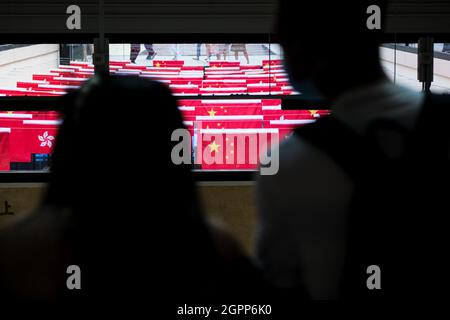 Hongkong. September 2021. Vor dem Nationalfeiertag der Volksrepublik China am 1. Oktober blicken die Menschen im Gebäude auf die chinesische und die Hongkonger Flagge. (Bild: © Keith Tsuji/ZUMA Press Wire) Bild: ZUMA Press, Inc./Alamy Live News Stockfoto