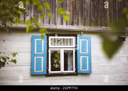 Fenster mit Fensterläden im traditionellen Holzhaus, Polen Stockfoto