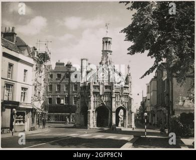 Market Cross, Chichester, West Sussex, 1952. Das Marktkreuz, von Westen aus gesehen. Das Marktkreuz wurde um 1500 erbaut, Glockenturm und Uhr wurden 1724 hinzugefügt. Das Kreuz wurde ursprünglich auf einem großen Platz aufgestellt, seitdem darauf gebaut. Als die Bevölkerung von Chichester wuchs, wurde der Markt im frühen 19. Jahrhundert vom Marktkreuz in das Markthaus an der North Street verlegt. Stockfoto