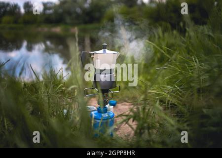 Kaffee auf Campinggas in der Natur machen Stockfoto