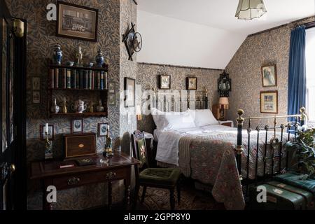 Blättrige Tapete mit Schreibtisch und Bett in Benedict's B&B, St. Leonards-on-Sea Stockfoto