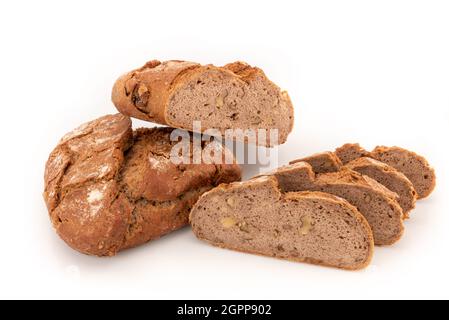 Buchweizenbrot knetete mit Walnüssen, einem ganzen Laib mit einem anderen, auf weißem Hintergrund isolierten, geschnittenen Brot Stockfoto