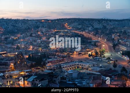 Türkei, Kappadokien, Goreme, Stadt beleuchtet in der Dämmerung und Felsformationen Stockfoto