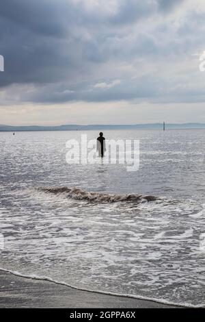 Eine halb untergetauchte Skulptur „Another Place“ von Sir Antony Gormley im Meer am Crosby Beach, Merseyside, Großbritannien, bekannt als The Iron Men Stockfoto