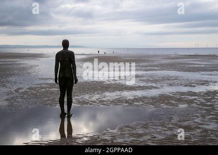 Eine von hundert gusseisernen Figuren, die Antony Gormley mit dem Titel „Another Place“ am Crosby Beach, Merseyside, Großbritannien, modelliert hat Stockfoto