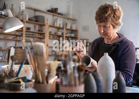 Spanien, Balearen, Frau Malerei Keramik in der Werkstatt Stockfoto