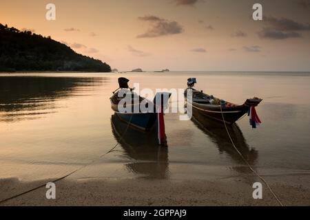 Thailand, Insel Ko Samui, traditionelle Boote, die bei Sonnenuntergang am Strand festgemacht sind Stockfoto