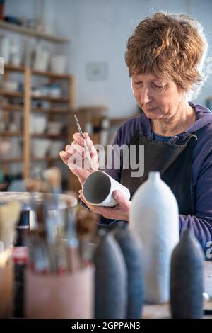 Spanien, Balearen, Frau Malerei Keramik in der Werkstatt Stockfoto