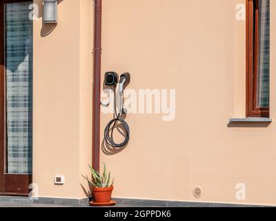 Eine spezielle Steckdose zum Aufladen von Elektroauto-Batterien, an der Wand eines Hauses befestigt Stockfoto