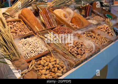 Schöne und dekorierte Ausstellung mit Naturprodukten, Brot, Erdnüssen, Käse, Mandeln, Bohnen, Kichererbsen, Linsen usw. Stockfoto