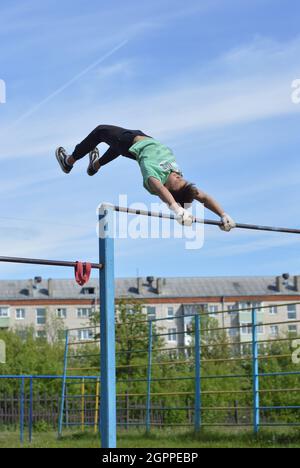 Kovrov, Russland. 11. Juni 2017. Teen ist in Disziplin Gimbarr auf einer horizontalen Bar im Schulhof beschäftigt Stockfoto