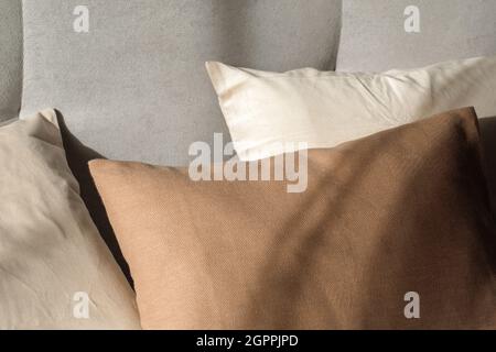 Leinenkissen in minimalistischer Innenausstattung. Beigefarbene, weiße und cremefarbene Kissen Stockfoto