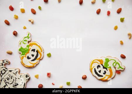 Halloween Kreative Leckereien: Hausgemachte Kürbiskekse mit getrockneten Früchten, kandierte Früchte, Cashewkerne, Haselnüsse. Trick or Treat-Konzept. Herbstliches gemütliches Hauskonzept mit gesunden Snacks. Speicherplatz kopieren. Stockfoto