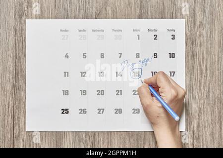 Kalender mit einem eingekreisten Datum und einem freien Tag auf einem hölzernen Hintergrund Stockfoto