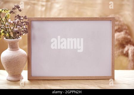 Minimalistischer imitierter Rahmen mit trockenen Blumendekorationen. Gemütliches Zuhause Atmosphäre Mockup. Hochwertige Fotos Stockfoto