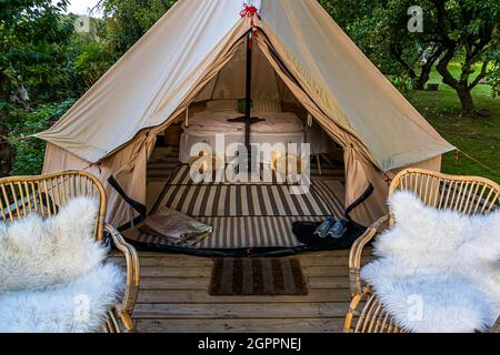 Glamping im Garten der Villa Skovly (Beths Hus) steht das geräumige Zelt mit Doppelbett auf einer Holzterrasse im Obstgarten. Die Villa Skovly gehört zur Familie Blixen. Der Familiensitz der dänischen Linie, die Barone von Blixen-Finecke, Schloss Hesselagergaard, befindet sich in der Nähe in Hesselager, Dänemark Stockfoto