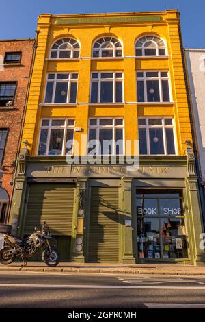 DUBLIN, IRLAND - 17. März 2021: Irland, Dublin, eine Aufnahme aus dem niedrigen Winkel des verwinkelten Restaurants Stair mit einem Buchladen und einem Fahrrad davor Stockfoto