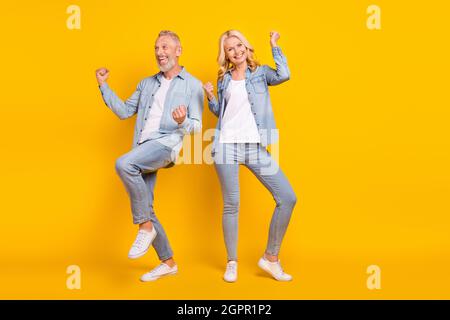 In voller Länge Foto von fröhlichen alten Menschen Ehegatten Gewinner feiern genießen isoliert auf gelbem Hintergrund Stockfoto