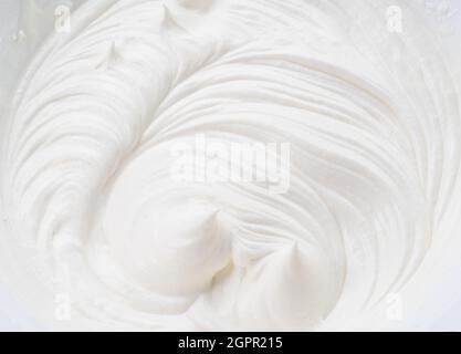 Cremige Pics und Wirbel in Joghurt oder Creme Oberfläche. Draufsicht. Stockfoto