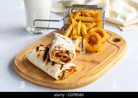 Hühnerpackung auf weißem Hintergrund. Mit pommes Frites und Zwiebelringen Stockfoto