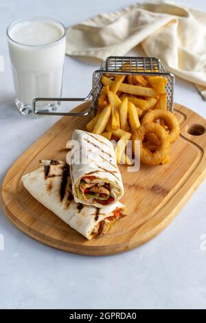 Hühnerpackung auf weißem Hintergrund. Mit pommes Frites und Zwiebelringen Stockfoto