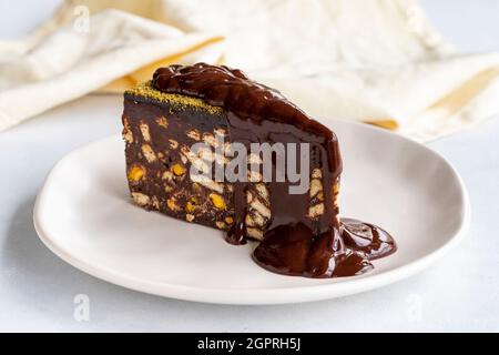 Mosaikkuchen mit Schokoladensauce auf weißem Hintergrund Stockfoto