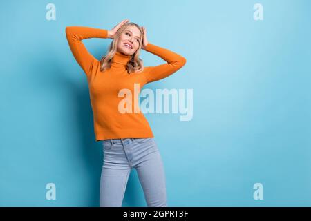 Foto von freudigen jungen glücklichen Frau suchen leeren Raum genießen Freizeit Wochenende isoliert auf blauem Hintergrund Stockfoto