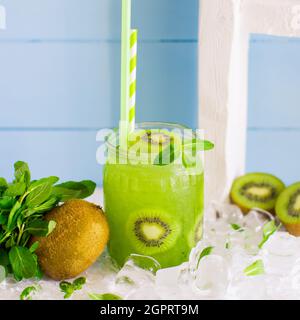Kiwi-Cocktail mit Kiwi-Stücken und Eis im Glasglas Stockfoto