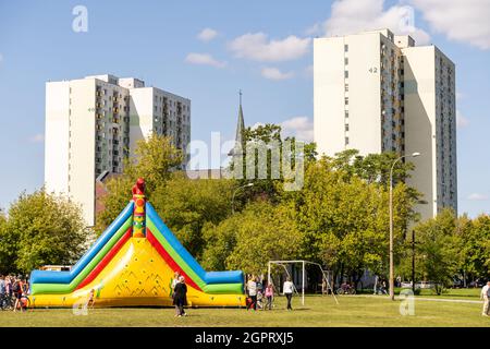 POZNAN, POLEN - 05. Sep 2021: Eine farbenfrohe, aufblasbare Rutschburg auf einem Grasfeld in der Nähe von Wolkenkratzern für eine Kinderveranstaltung in Polen Stockfoto