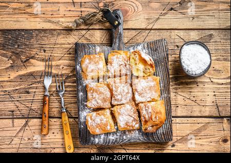 Griechisches Gebäck Bougatsa mit Phyllo-Teig und Grießpudding Sahne. Holzhintergrund. Draufsicht Stockfoto