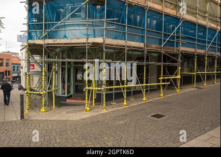 Gerüste auf einem großen Gebäude in Norwich City mit Warnband auf dem unteren Gerüst Stockfoto