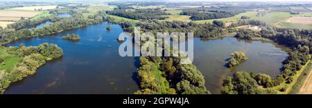 Panorama, Luftaufnahme eines Abschnitts des Little Stour Chalk Baches, der zwischen zwei alten, mit Wasser gefüllten Kiesgruben in der Nähe von Wickhambreaux, Kent, fließt Stockfoto