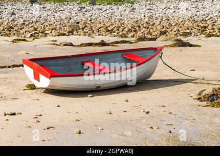 Ein rot-weißes Holzboot am Strand von Kitchen Porth, Bryher, Isles of Scilly Stockfoto