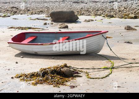 Ein rot-weißes Holzboot am Strand von Kitchen Porth, Bryher, Isles of Scilly Stockfoto