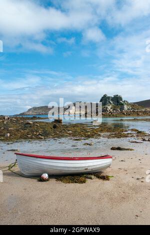 Ein rot-weißes Holzboot am Strand von Kitchen Porth, Bryher, Isles of Scilly Stockfoto