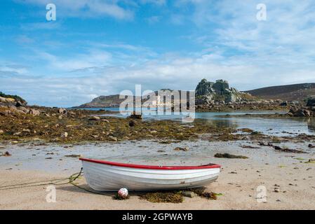 Ein rot-weißes Holzboot am Strand von Kitchen Porth, Bryher, Isles of Scilly Stockfoto